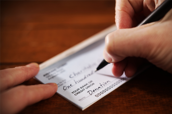 closeup of hand writing a check